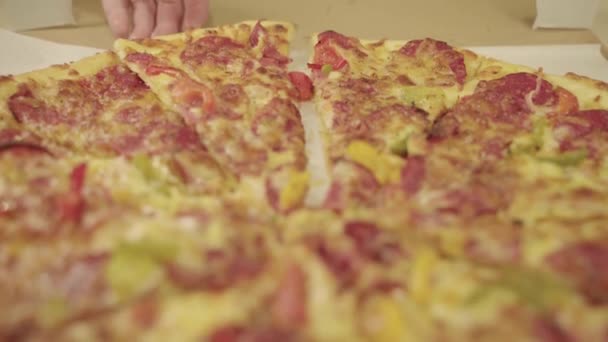 Mänskliga händer ta skivor av färsk pizza från en öppen låda. — Stockvideo