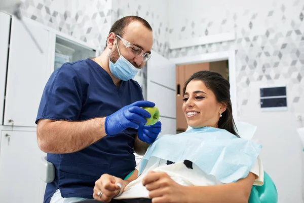 Persone, medicina, stomatologia e concetto di assistenza sanitaria - felice dentista di sesso maschile che mostra il piano di lavoro per la paziente donna presso lo studio della clinica dentale — Foto Stock