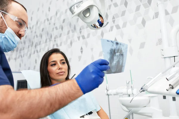 Persone, medicina, stomatologia e concetto di assistenza sanitaria - felice dentista di sesso maschile che mostra il piano di lavoro per la paziente donna presso lo studio della clinica dentale — Foto Stock