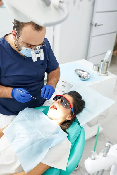 Mensen, geneeskunde, stomatologie en gezondheidszorg concept - gelukkige mannelijke tandarts met vrouw patiënt op tandheelkundige kliniek kantoor — Stockfoto
