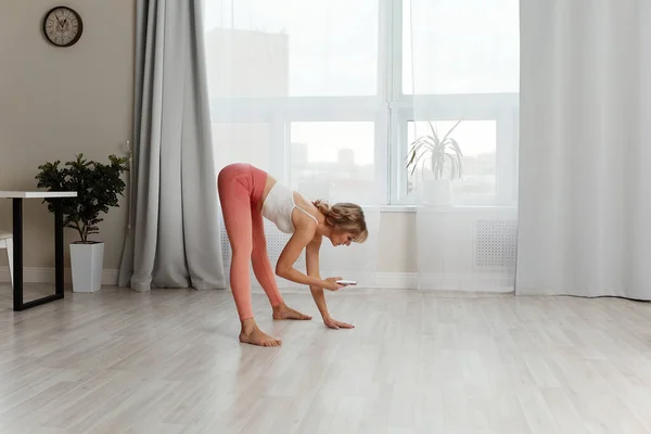 Fitness a casa. Hermosa mujer haciendo algunos ejercicios en casa en una sala de estar. — Foto de Stock