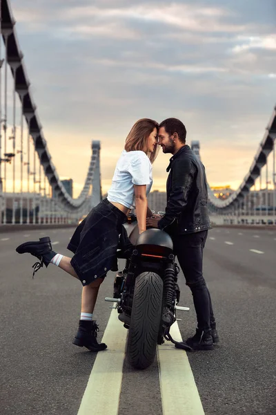 爱情和浪漫的概念。美丽的一对骑摩托车的情侣在桥中央相对地站着，双双立正 — 图库照片
