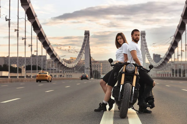 Miłość i romantyczna koncepcja. Piękna para na motocyklu stoi naprzeciwko siebie na środku drogi na moście, na podwójnej bryle — Zdjęcie stockowe