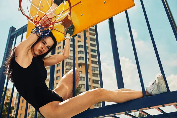 Mujer deportiva fuerte y sexy entrenando al aire libre, en el suelo. saltó a la canasta de baloncesto — Foto de Stock