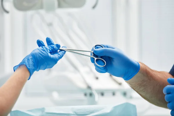 Detailní záběr rukou zubaře a ošetřujícího lékaře na operačním sále během operace zubního implantátu — Stock fotografie
