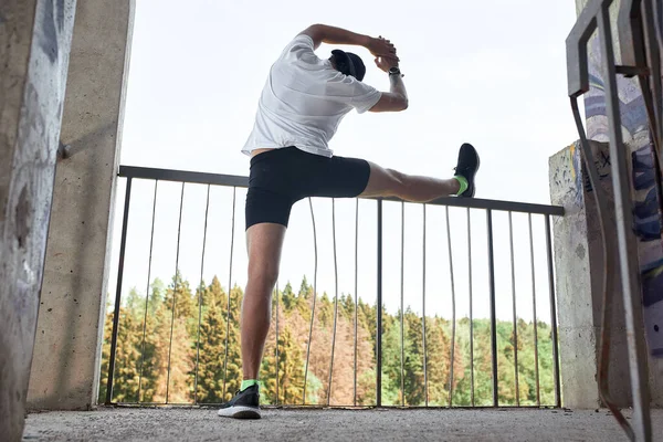 Atleta masculino concentrado corriendo escaleras arriba para hacer el entrenamiento más intensivo. Deportivo joven guapo entrenando solo al aire libre. Concepto de entrenamiento de escalera — Foto de Stock