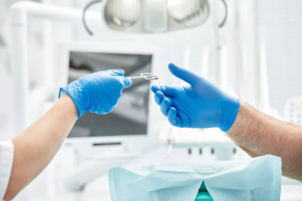 Close-up das mãos de um dentista e enfermeiro cirurgião sobre uma sala de cirurgia durante uma operação de implante dentário — Fotografia de Stock