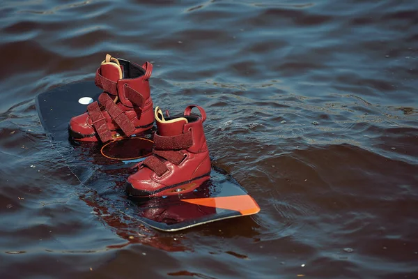 Equipamiento, botas, tabla, cuerda para wakeboarding en el lago del río mar en verano día de primavera. — Foto de Stock