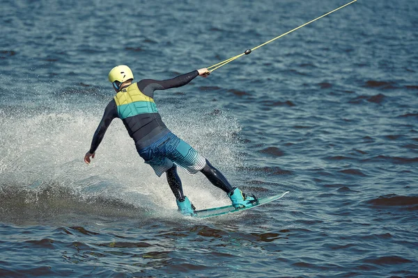 Ten chlap jede na wakeboardu na řece. Aktivní a extrémní sporty — Stock fotografie