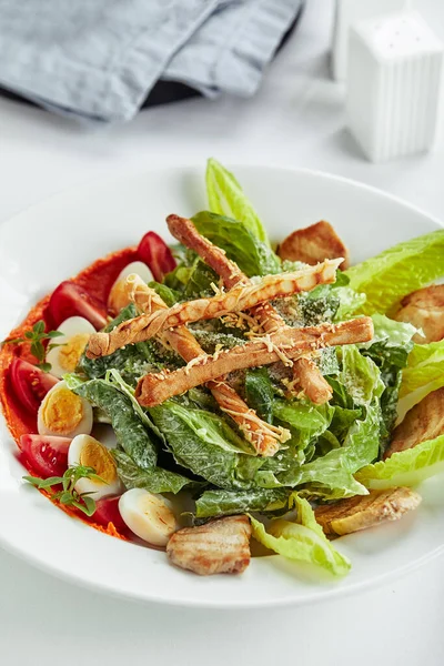 Caesar-Salat mit Stockbrot, Wachteleiern, Kirschtomaten und gegrilltem Huhn auf weißem Hintergrund — Stockfoto