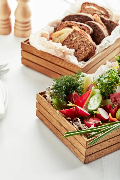 Подрібнені свіжі овочі в дерев'яній коробці на білому тлі. Банкетні святкові страви. Меню ресторану гурмана . — стокове фото