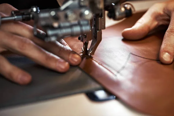 Proceso de trabajo del artesano del cuero. Tanner o skinner cose el cuero en una máquina de coser especial, cerca de costura up.worker en la máquina de coser —  Fotos de Stock