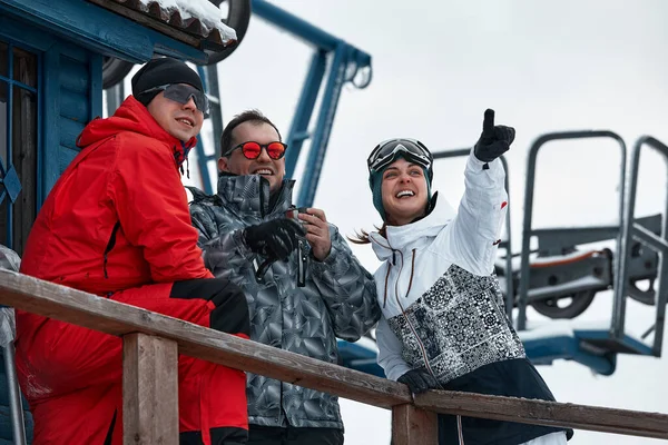 Groep skiërs vrienden op de berg rusten uit en drinken koffie uit een thermoskan op de achtergrond van de skilift — Stockfoto