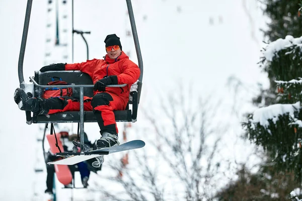 Esquiador sentado en telesilla en las altas montañas durante el día soleado. Deportes de invierno y recreación, actividades al aire libre de ocio. —  Fotos de Stock