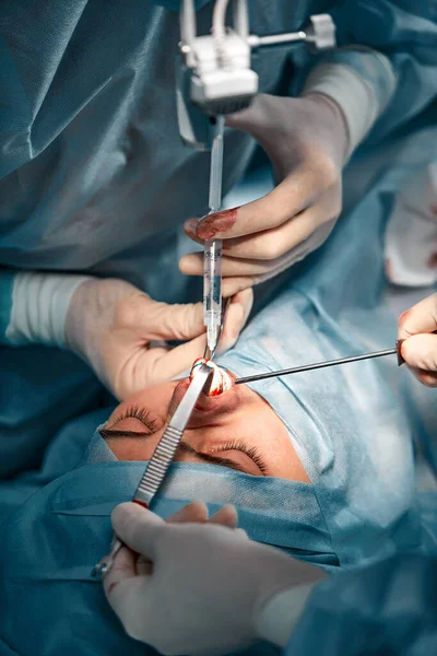 Los hombres de rinoplastia, los cirujanos con guantes de manos sostienen los instrumentos durante la cirugía de la nariz. Médico con guantes sostiene un instrumento médico durante la rinoplastia — Foto de Stock