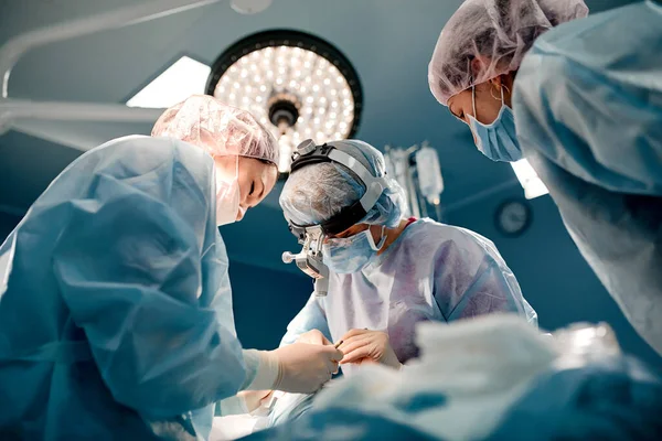 Un equipo de cirujanos está luchando por la vida, por una operación real, por emociones reales. El equipo de cuidados intensivos está luchando por la vida del paciente. Salvar la vida, la lucha por la vida — Foto de Stock
