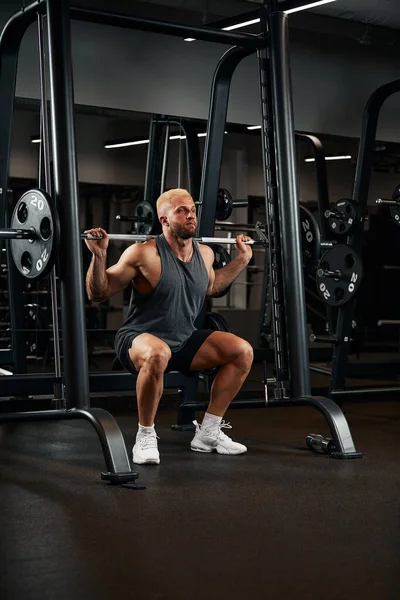 一个肌肉男带着杠铃在体育馆锻炼的特写镜头。健美健美运动员，六包，完美的腹肌、肩膀、二头肌、三头肌和胸部 — 图库照片