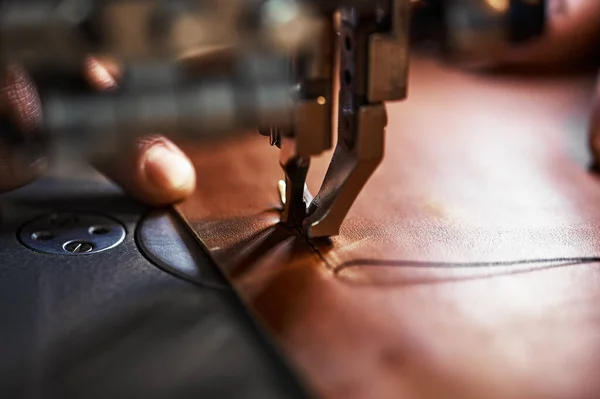 Робочий процес шкіряного майстра. Таннер або скейтер шиє шкіру на спеціальній швейній машинці, крупним планом. — стокове фото