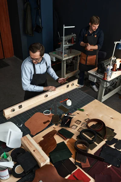 Bőr kézművesek dolgozik, hogy mérések mintákat az asztalnál műhely stúdió — Stock Fotó