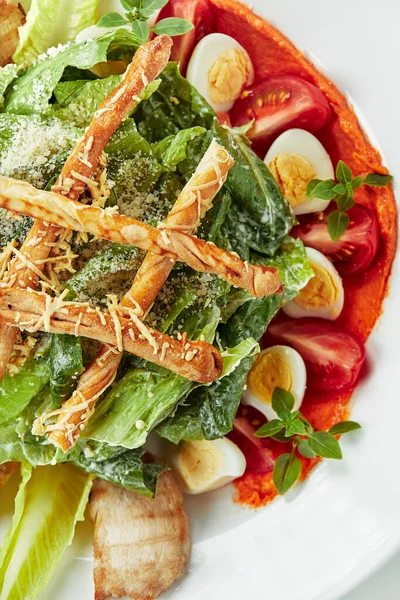 Caesar-Salat mit Stockbrot, Wachteleiern, Kirschtomaten und gegrilltem Huhn auf weißem Hintergrund — Stockfoto