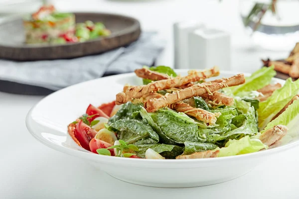 Caesar-Salat mit Stockbrot, Wachteleiern, Kirschtomaten und gegrilltem Huhn auf weißem Hintergrund — Stockfoto