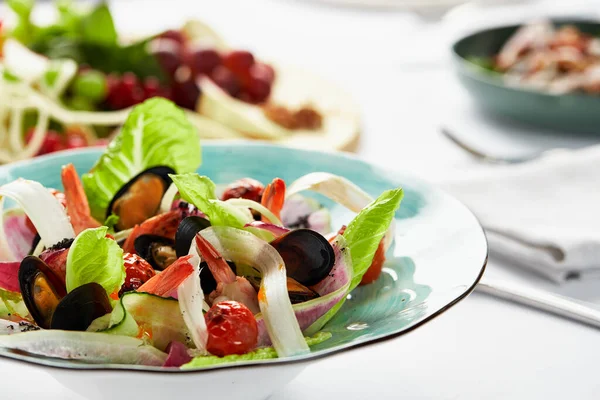 Muscheln Vongole in einem Teller mit Salat, Miesmuscheln in Weißweinsoße gekocht, auf einem Tisch, mit weißem Scart, Salat vom Chef der Meeresfrüchte-Miesmuscheln und Rumblätter und Lola rosa — Stockfoto