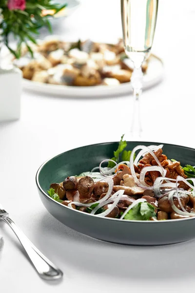 Verschiedene gesalzene Pilze, auf einem Teller auf einem festlich gedeckten Tisch mit weißen Tischdecken, eine Mischung aus Lanzenpilzen — Stockfoto