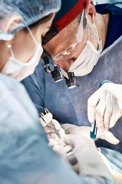 在手术台上方的手术中，一组男女外科医生，现代设备的医生进行肿瘤手术 — 图库照片