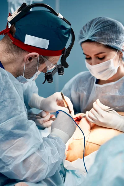 Os cirurgiões modernos operam no câncer de mama, mamoplastia, os médicos enfrentam close-up. — Fotografia de Stock