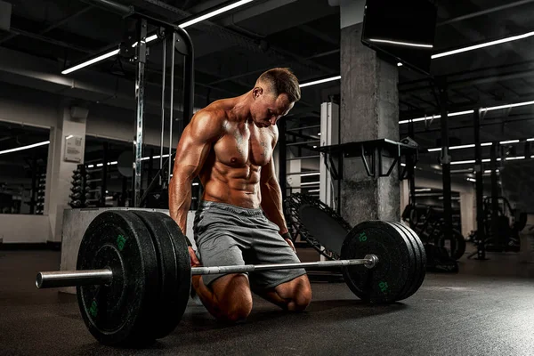 Fatigue des entraînements quotidiens, le bodybuilder rassemble son esprit avant l'exercice d'haltère, la motivation sportive, se dépasser. — Photo