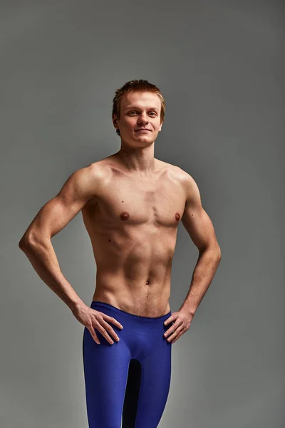 Jovem atleta nadador, em shorts sobre fundo cinza, retrato de um atleta nadador no estúdio — Fotografia de Stock