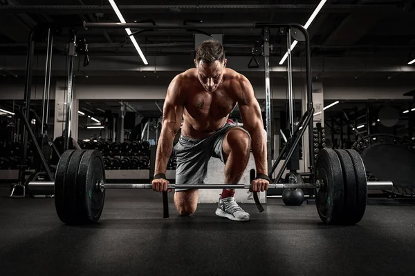 Atleet, man doet deadlift met een lange halter jonge atleet voor te bereiden op een zware gewicht lange halter tillen workout — Stockfoto