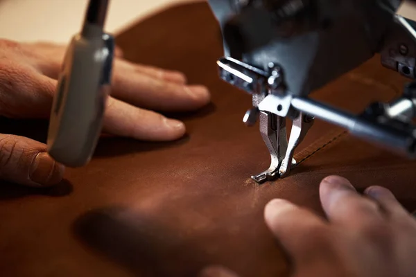 Fluxo de trabalho do trabalhador de couro. Um curtidor ou skinner costura couro em uma máquina de costura especial. Um trabalhador costura em uma máquina de costura, visão em primeira pessoa. — Fotografia de Stock