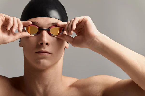 Nadador en una gorra y máscara, sobre un fondo gris, preparándose para nadar, primer plano, banner publicitario para piscinas, espacio para copiar — Foto de Stock