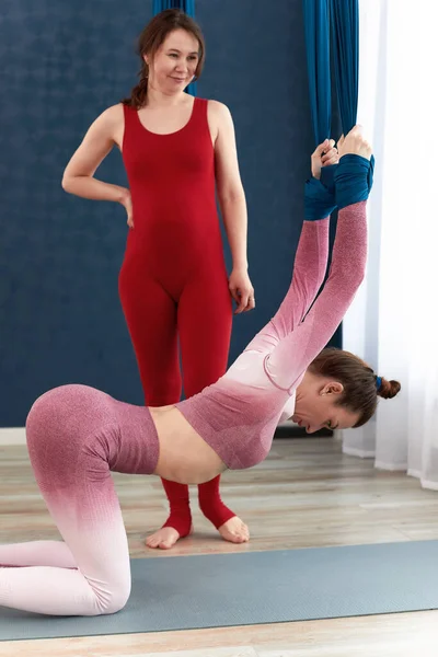 Kurse in einer Lufthängematte unter Anleitung eines Yogalehrers, Gesundheitsförderung während der Schwangerschaft, Anti-Schwerkraft-Yoga-Kurse. — Stockfoto