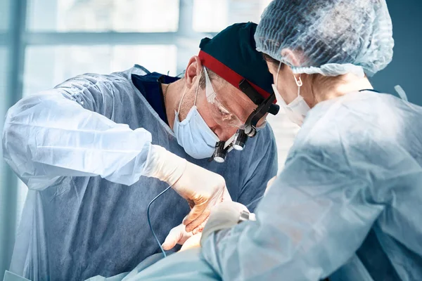 Gros plan des chirurgiens dans la salle d'opération pendant l'opération.Médecine moderne, Travailleurs médicaux pendant la pandémie de coronavirus Covid19 combattent et sauvent des vies. — Photo