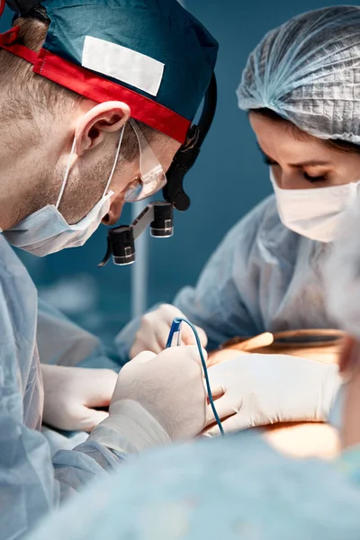 Chirurgenassistentin füttert Gerinnungsapparat, plastische Chirurgie, professionelle Ärzte, Nahaufnahme. — Stockfoto