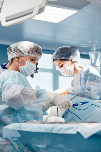 El trabajo duro de un equipo de cirujanos, el trabajo duro de los médicos profesionales durante una operación compleja y larga, el teatro de la sala de cirugía, salvar vidas. —  Fotos de Stock