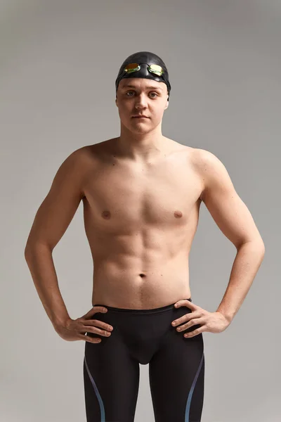 Retrato de um nadador em boné e máscara, retrato de meia-distância, jovem atleta nadador usando um boné e máscara para nadar, cópias do espaço, fundo cinza — Fotografia de Stock