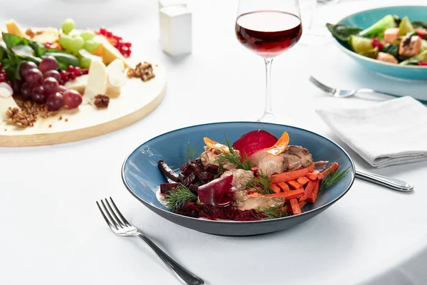 Hummus mit Gemüse, Rüben-Hummus mit gebratenen Gemüsesticks und Svela-Blättern, ein festlicher Tisch mit Snacks und Wein. — Stockfoto