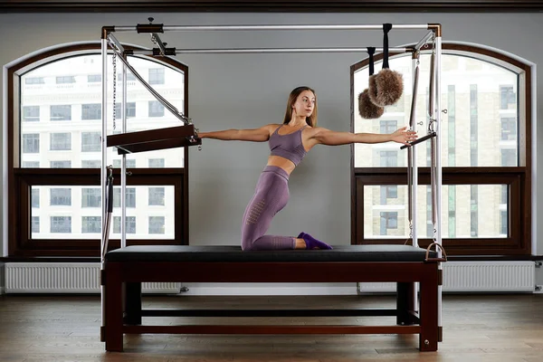 Spor salonunda Pilates için modern ekipman Cadilac yenilikçisi, sağlık ve rehabilitasyon kavramı, eğitmen kas iskeleti sistemini düzeltmek için reformcu üzerinde çalışmalar yapıyor.. — Stok fotoğraf