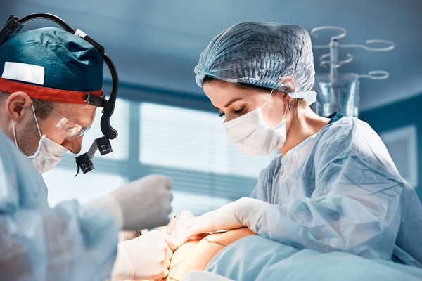 Primer plano de los cirujanos en el quirófano durante la operación.Medicina moderna, Los trabajadores médicos durante la pandemia del coronavirus Covid19 luchan y salvan vidas. —  Fotos de Stock