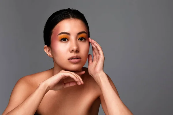 Retrato de uma beleza menina asiática, belo rosto feminino com pele limpa e saudável, close-up em um fundo cinza, espaço de cópia — Fotografia de Stock