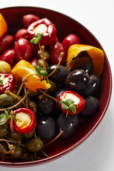 Verdure sottaceto in un piatto, olive, olive nere, peperoni ripieni, ravanelli. Verdure assortite, verdure con spezie sott'olio primo piano — Foto Stock