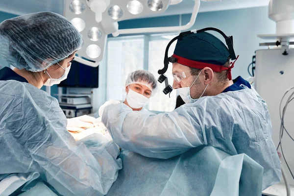 Une équipe de chirurgiens hommes et femmes pratiquant une chirurgie cardiaque complexe, une chirurgie cardiovasculaire, une médecine moderne, un traitement cardiaque — Photo