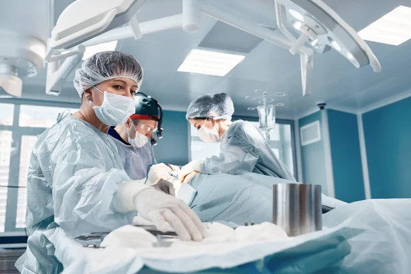 El trabajo duro de un equipo de cirujanos, el trabajo duro de los médicos profesionales durante una operación compleja y larga, el teatro de la sala de cirugía, salvar vidas. — Foto de Stock