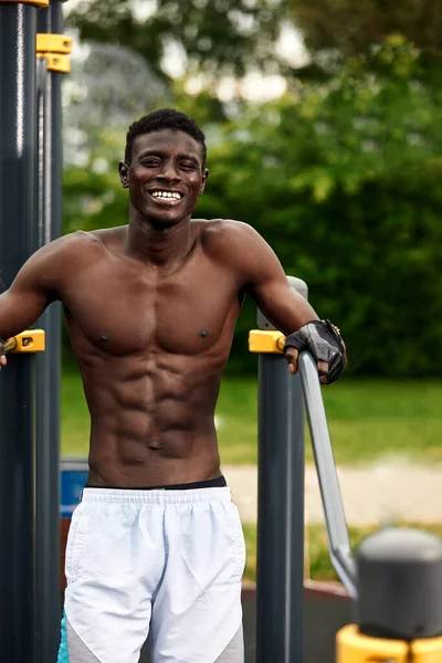 Schwarzer Athlet beim unebenen Barren auf dem Straßenpodest, muskulöser Afroamerikaner beim Workout, Crossfit-Konzept — Stockfoto