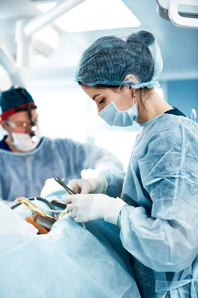 Primer plano de médicos y enfermeras en quirófano, médicos profesionales durante el trabajo en quirófano moderno, concepto de cirugía plástica —  Fotos de Stock