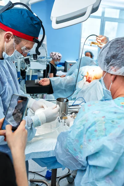 Chirurdzy podczas operacji z implantami piersi w rękach, montażem implantów piersi, operacją. Chirurgia plastyczna, korekcja piersi, mammoplastyka. — Zdjęcie stockowe