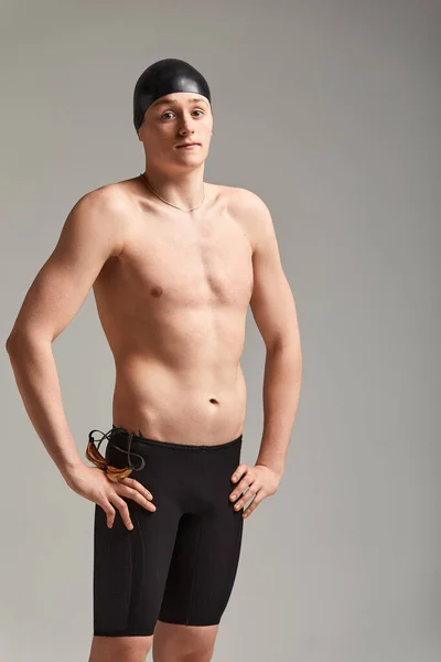 Retrato de um nadador em boné e máscara, retrato de meia-distância, jovem atleta nadador usando um boné e máscara para nadar, cópias do espaço, fundo cinza — Fotografia de Stock